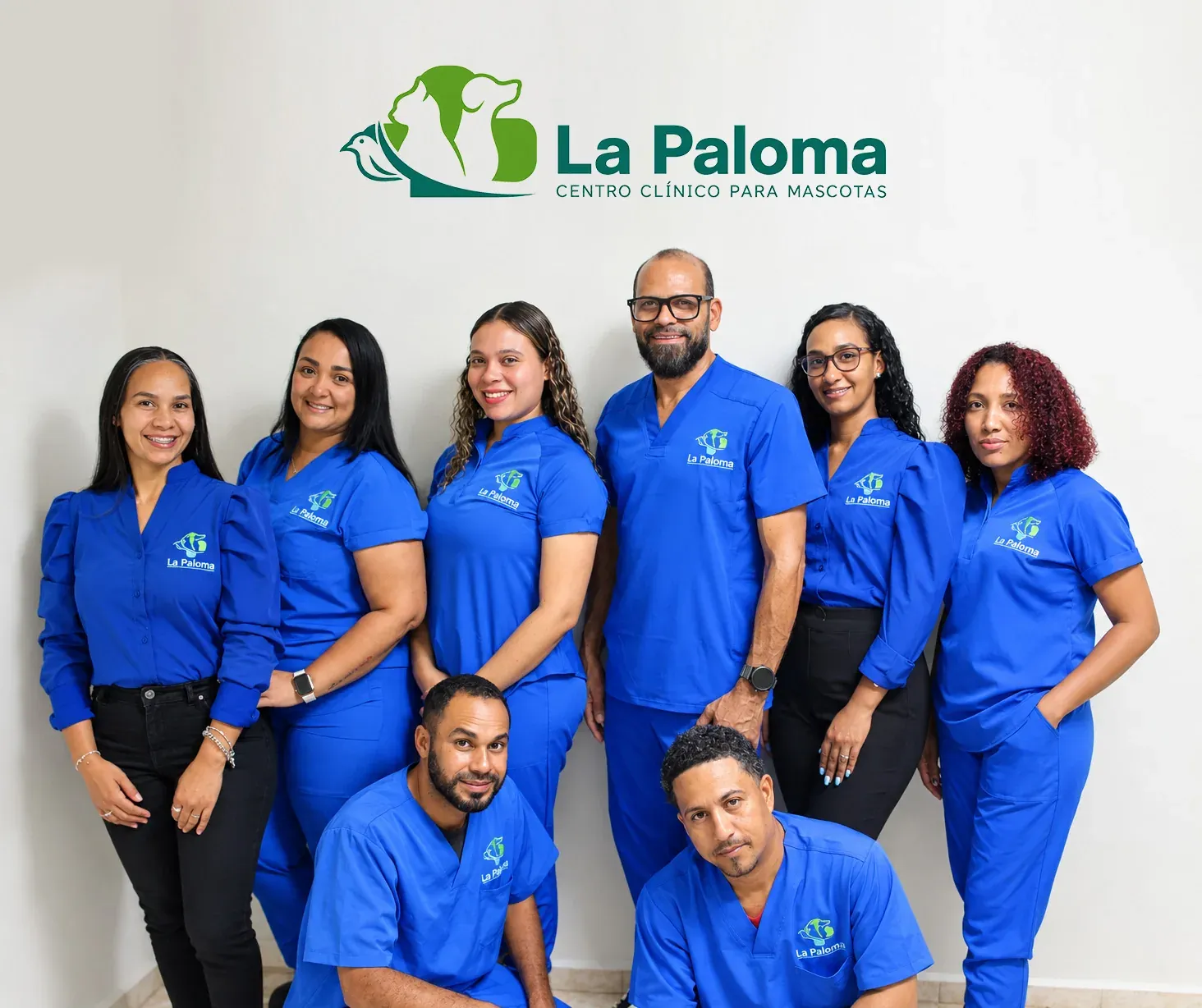 El equipo de La Paloma con su uniforme azul, bajo el logo de la clínica en Bonao