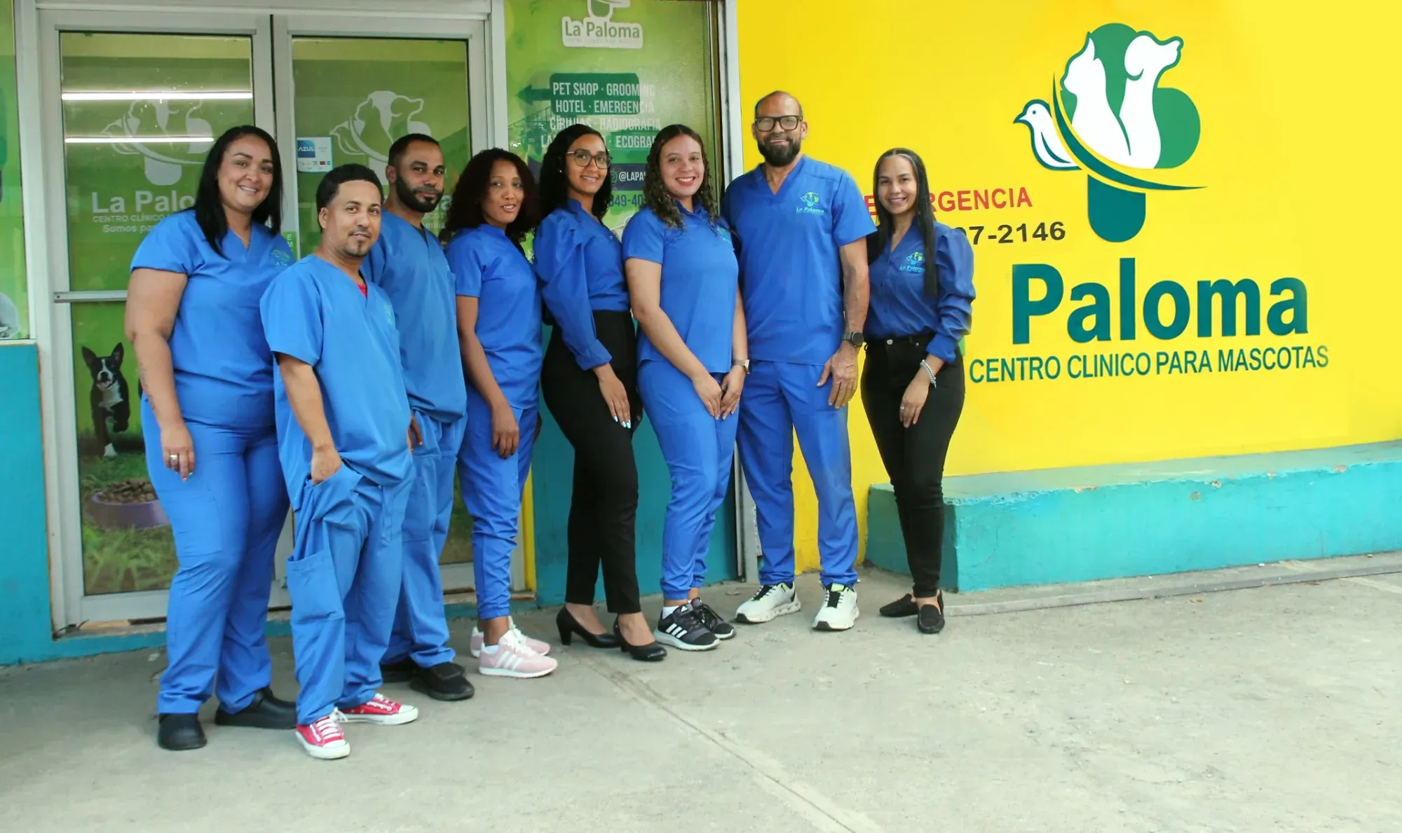 El equipo de La Paloma, con su uniforme azul, frente a la clínica en Bonao